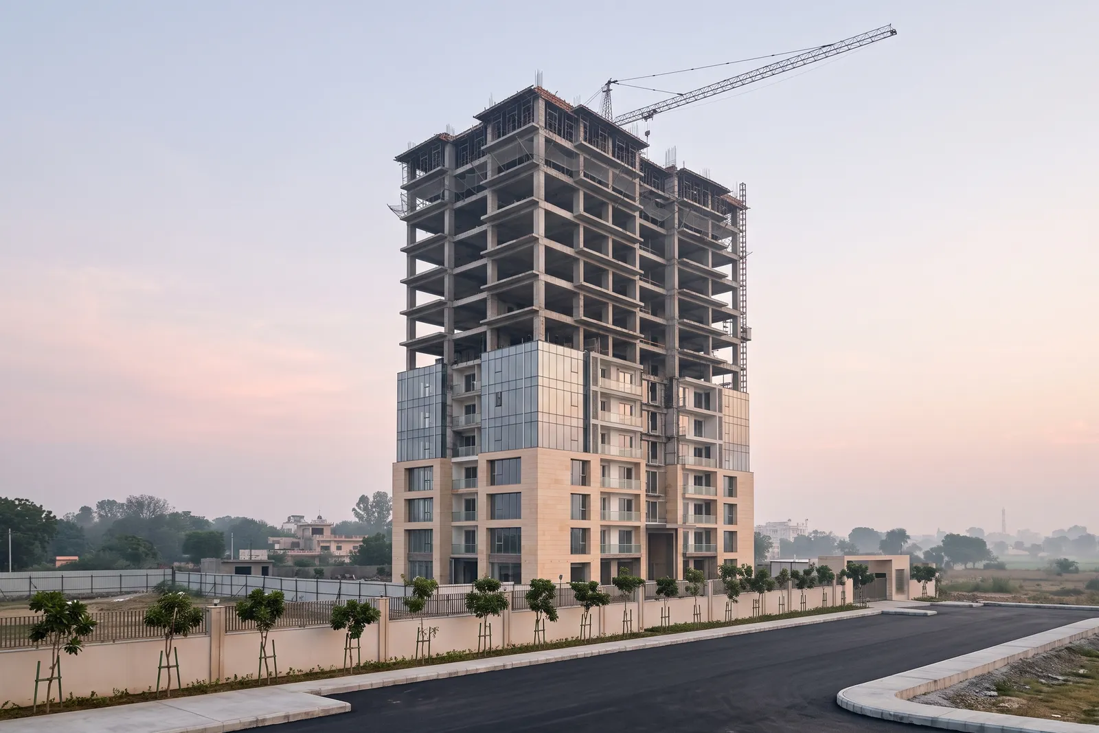 A residential tower under construction at dawn, its lower floors finished and its upper floors still a concrete frame
